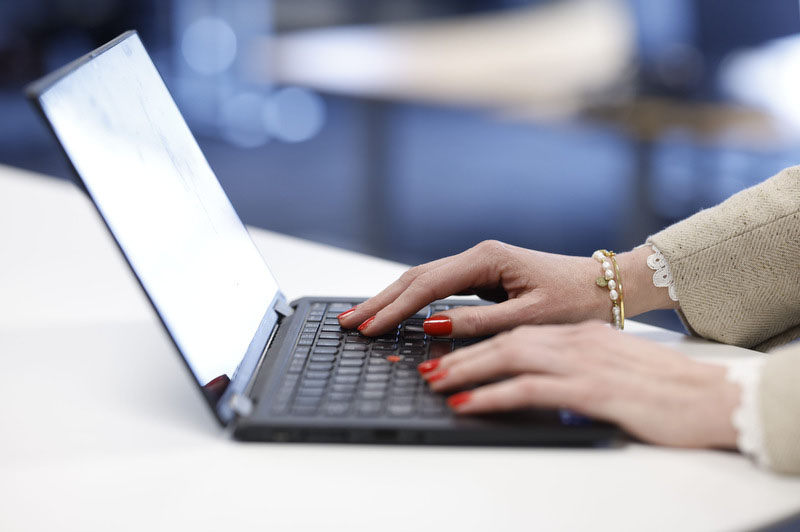 Bild på en kvinnas fingrar som skriver på en laptop.
